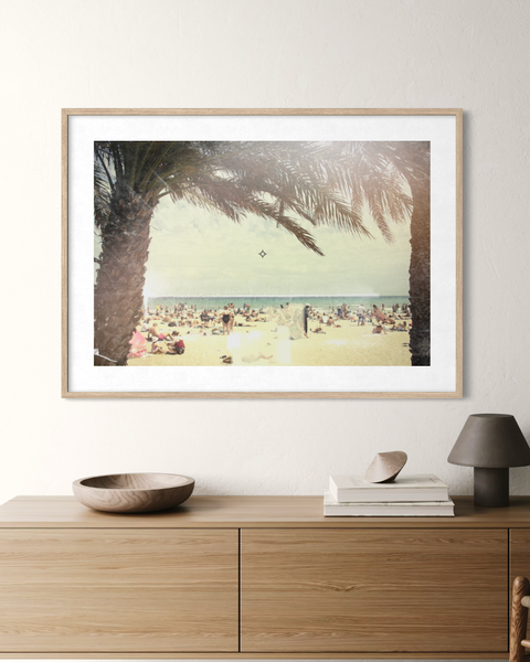 Framed beach scene on a wall above a wooden console table in a modern room.
